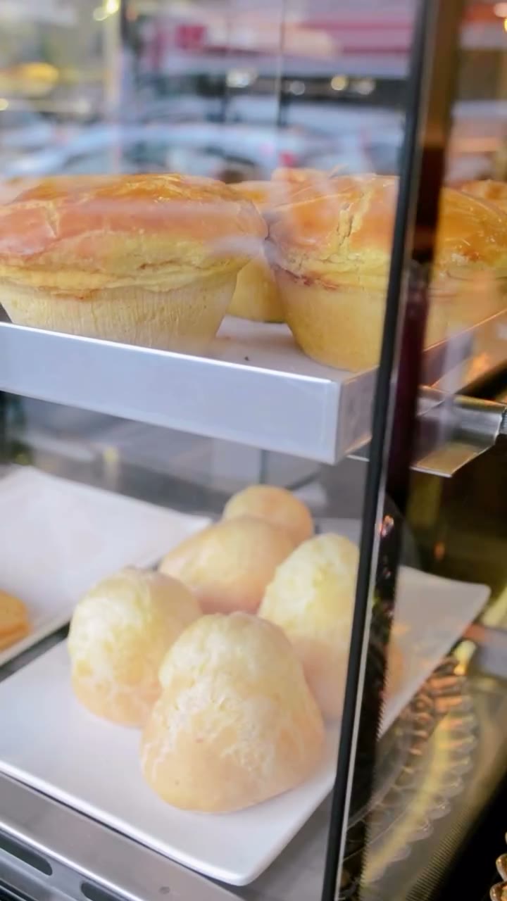 Vitrine com pães de queijo e tortas